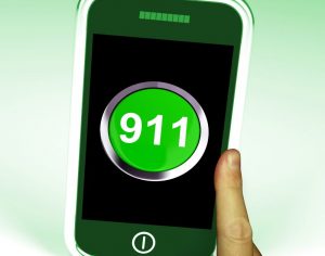 Cell phone showing "911" and hand preparing to dial number