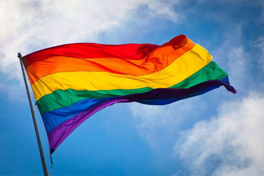 Image of a Rainbow flag flapping in the wind.