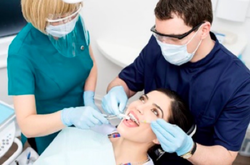 A dentist filling a woman's cavity.
